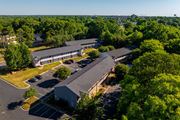 Kannapolis apartment for rent - a view from above of a building with a parking lot and trees at Ashford Place Apartments, Kannapolis, NC 28081