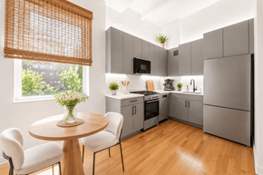New York apartment for rent - A modern kitchen with a table and chairs by the window.