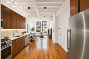 New York apartment for rent - A modern kitchen with wooden cabinets and a stainless steel refrigerator.
