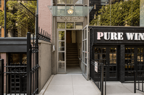 New York apartment for rent - A black gate blocks the entrance to a building with a Pure Wine sign.