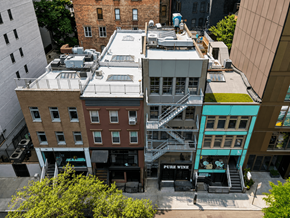 New York apartment for rent - A view of a city street with buildings and a sign that says