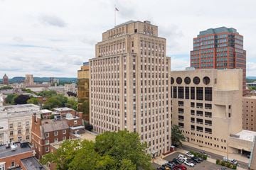 New Haven apartment for rent - A cityscape with a large building in the center and a flag on top.