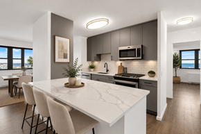 Atlantic Highlands apartment for rent - A modern kitchen with a marble countertop and white chairs.