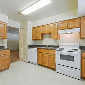 Baltimore townhouse for rent - a kitchen with white appliances and wooden cabinets