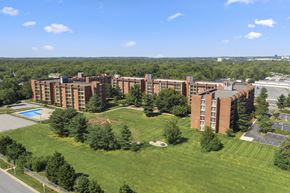 Laurel apartment for rent - A large red brick building with a pool in the front yard.