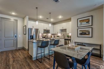 A kitchen and dining area with large island and stainless steel appliances