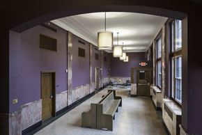 Wausau apartment for rent - A long hallway with purple walls and a bench in the middle.