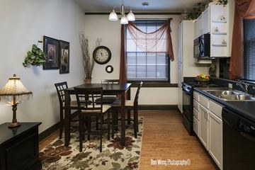 Wausau apartment for rent - A kitchen with a table and chairs in the middle.