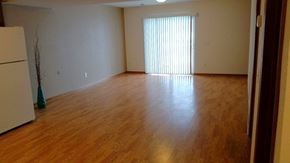 Albert Lea townhouse for rent - A room with wooden floors and a white refrigerator.