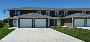 Albert Lea townhouse for rent - A large house with a grey roof and a grey garage door.
