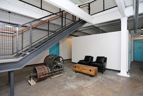 Wausau apartment for rent - A room with a couch, a table, and a staircase.