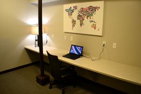 Eau Claire apartment for rent - A laptop is on a desk with a world map on the wall behind it.