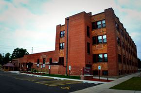 Eau Claire apartment for rent - A red brick building with a parking lot in front.