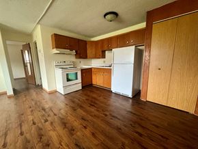 Winona apartment for rent - A kitchen with wooden floors and white appliances.