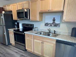 New Richmond apartment for rent - A kitchen with wooden cabinets and a fridge.