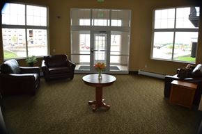 Ames apartment for rent - A waiting room with a table in the middle and chairs around it.
