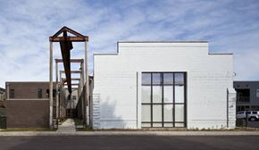 Wausau apartment for rent - A white building with a large window and a wooden structure in front.