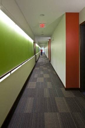 Wausau apartment for rent - A long hallway with a red exit sign at the end.