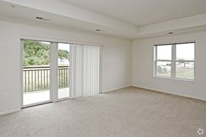 Rochester apartment for rent - A spacious room with a sliding glass door leading to a balcony.