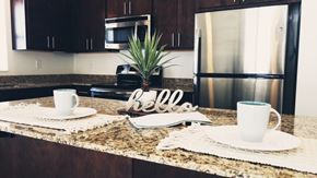 Rochester apartment for rent - A kitchen counter with a sign that says "hello" and two cups on it.