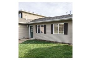 Chatfield apartment for rent - A house with a green door and black shutters.