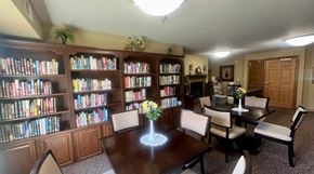 Winona apartment for rent - A room with a table, chairs, and bookshelves filled with books.