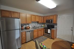 Durham apartment for rent - A kitchen with wooden cabinets and a stainless steel refrigerator.