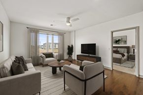 Sun Prairie apartment for rent - A living room with a grey couch, a coffee table, and a television.