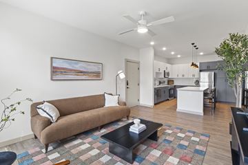 Austin apartment for rent - A living room with a brown couch and a ceiling fan.