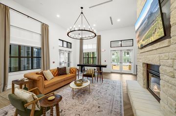 Boerne apartment for rent - A living room with a fireplace and a large painting on the wall.