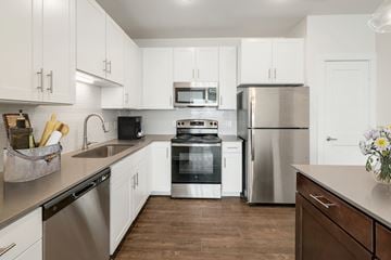 Hutto apartment for rent - A kitchen with white cabinets and stainless steel appliances.