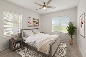 Hutto apartment for rent - A bedroom with a bed, a ceiling fan, and a potted plant at The Narrows in Hutto, TX.