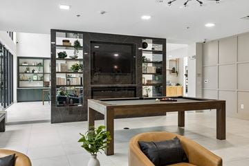 Farmers Branch apartment for rent - A modern living room with a pool table and a fireplace.