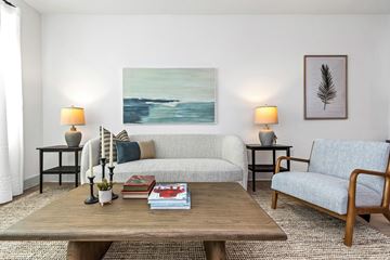 Clearwater apartment for rent - A living room with a couch, two chairs, a coffee table, and a painting on the wall.