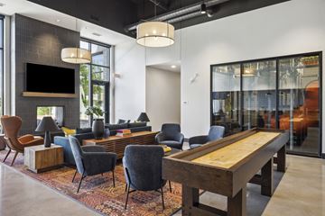 Minneapolis apartment for rent - A modern living room with a wooden table and grey chairs.