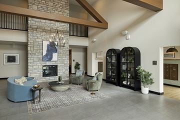 Rosemount apartment for rent - A living room with a stone fireplace and a large painting above it.