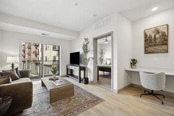 Victoria apartment for rent - A living room with a brown couch, a coffee table, a chair, and a painting on the wall.
