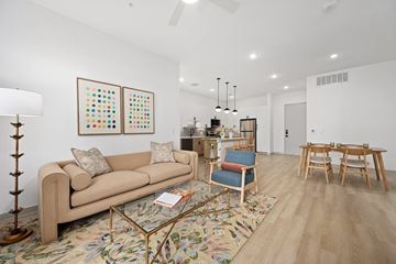 Austin apartment for rent - A living room with a tan couch, a coffee table, and a rug with a floral pattern.