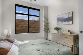 Salt Lake City apartment for rent - A bedroom with a large bed and a painting on the wall at The Whitney in Salt Lake City, Utah.