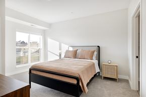 Shakopee apartment for rent - A bedroom with a large bed and a window overlooking a street at The Blakeley in Shakopee, MN.