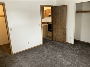 Brigham City apartment for rent - a bedroom with a door to a kitchen and a carpeted floor