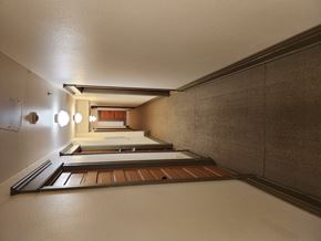 Missoula apartment for rent - A long hallway with a brown floor and white walls.