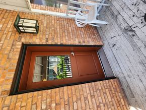 Missoula apartment for rent - A window with a brown wooden door and a white chair on the wall.