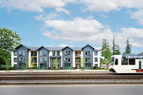 Portland apartment for rent - A train is passing by a row of houses.