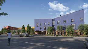 Hillsboro apartment for rent - A man is walking on the street in front of a purple building.