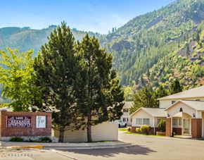 Missoula apartment for rent - A sign for Creekside Apartments is in front of a building with a mountain in the background.