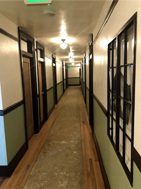 Astoria apartment for rent - A long hallway with doors on the left and windows on the right.