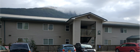 Douglas apartment for rent - a building with a mountain in the background and cars parked in front