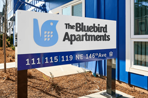 Portland apartment for rent - A sign for The Bluebird Apartments is displayed in front of a building.