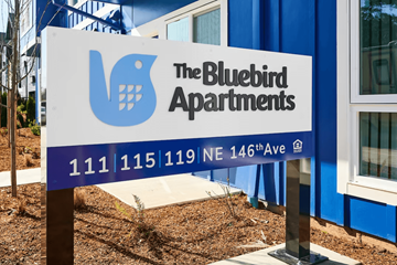 Portland apartment for rent - A sign for The Bluebird Apartments is displayed in front of a building.
